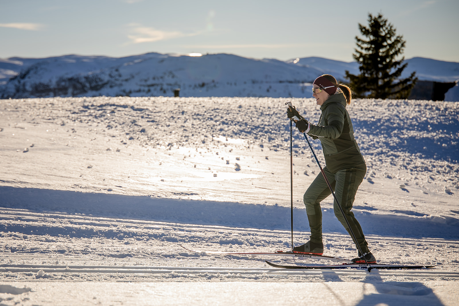 Langrennsløper på ski på Gålå med fjell i bakgrunnen