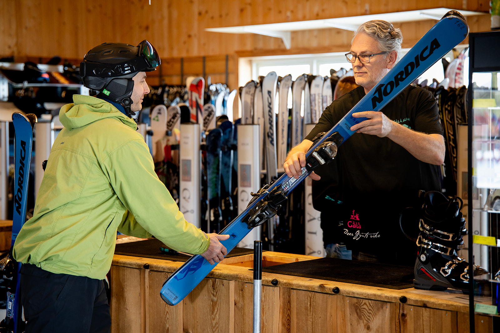 Ansatt i skiutleien på Gålå hjelper en gjest med tilpasning av skiutstyr